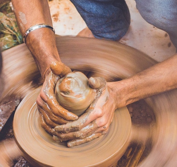 Person working clay on a wheel